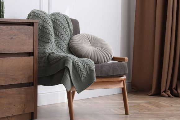 Gemütliche Ecke mit Kommode und Sessel.